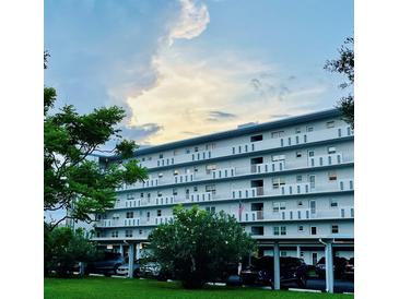 Multi-story condo building with balconies and covered parking on a lush green lawn at 4240 Ironwood Cir # 302A, Bradenton, FL 34209