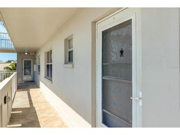 Hallway featuring secure unit entry door with glass and screen, and an exit at the end of the hall at 4240 Ironwood Cir # 302A, Bradenton, FL 34209