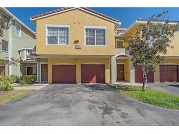 Inviting townhouse featuring a red tile roof, yellow stucco and private garage at 5601 Bentgrass Dr # 10-115, Sarasota, FL 34235
