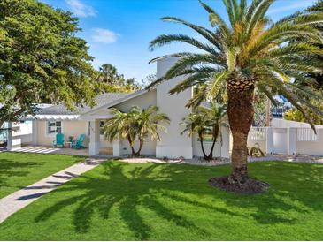 Charming home with a lush green lawn, mature trees and attractive landscaping, a welcoming sight for all at 106 N Blvd Of The Presidents, Sarasota, FL 34236