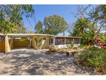 Charming yellow home featuring a screened-in porch and well-maintained landscaping at 109 Burney Rd, Osprey, FL 34229