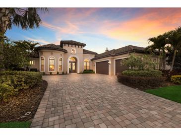 Beautiful home featuring a paver driveway, manicured landscaping, and a three-car garage at 11739 River Shores Trl, Parrish, FL 34219