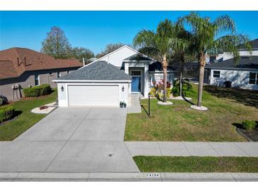 Charming single-story home featuring a well-manicured lawn, two-car garage, and inviting front entrance at 14150 Cattle Egret Pl, Lakewood Ranch, FL 34202