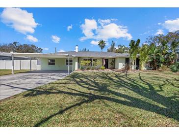 Charming single-story home with a carport, manicured lawn and established landscaping at 1450 Palmetto St, Clearwater, FL 33755