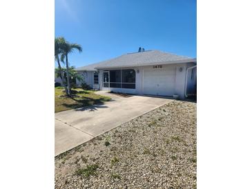 Charming single-story home featuring a one-car garage and a screened-in porch, surrounded by palm trees at 1472 Nantucket Rd, Venice, FL 34293