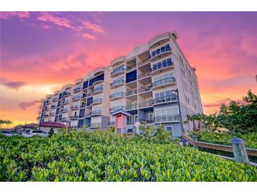 Beautiful condo building with sunset, balconies, landscaping, and luxurious architectural features at 501 Tamiami N Trl # 601, Venice, FL 34285