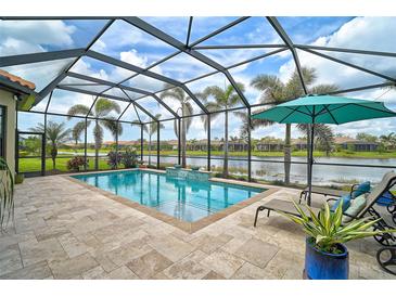 Enclosed pool with lake view, an umbrella, and tiled deck, surrounded by palm trees at 5656 Cantucci St, Nokomis, FL 34275