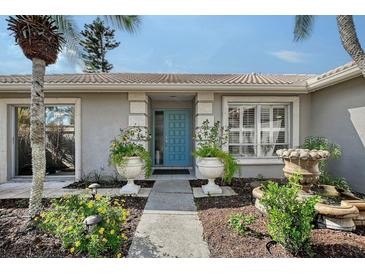 Charming home featuring a vibrant blue front door flanked by decorative planters and a stone fountain at 6684 Easton Dr, Sarasota, FL 34238