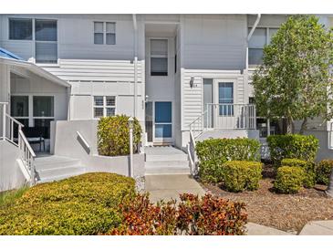 Inviting two-story condo featuring a private entrance, lush landscaping, and well-lit entryway at 803 Audubon Dr # 803, Bradenton, FL 34209
