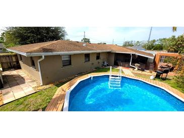 Backyard view of the sparkling blue pool, lush greenery, and relaxing patio area at 1011 68Th W Ave, Bradenton, FL 34207