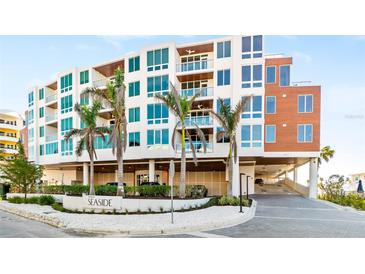 Modern condominium building with covered parking, lush landscaping, and convenient beach access at 1035 Seaside Dr # 603, Sarasota, FL 34242