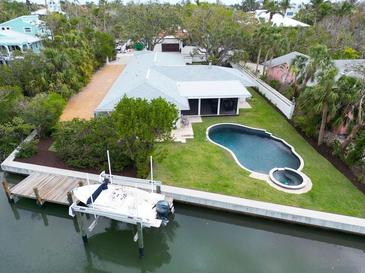 Beautiful waterfront home featuring a boat lift, backyard pool and patio on a meticulously landscaped lot at 110 Faubel St, Sarasota, FL 34242