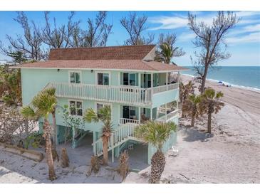 Coastal two-story home showcasing a beachside elevation, covered decks, and tropical landscaping at 2350 N Beach Rd # 1A, Englewood, FL 34223