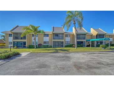 Charming condo with a well-maintained lawn and mature palm trees on a bright sunny day at 503 Albee Farm Rd # B6, Venice, FL 34285