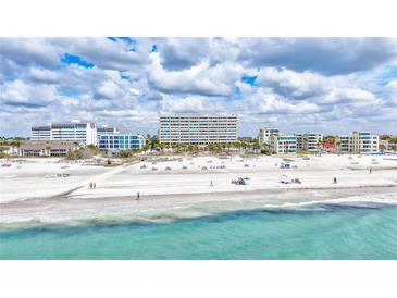 Beautiful white sand beach and ocean view with residential buildings in the background at 6140 Midnight Pass Rd # 103, Sarasota, FL 34242