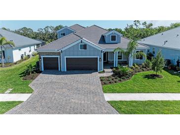 Beautiful single-Gathering home with a three-car garage, lush landscaping, and a brick paved driveway at 8046 Anthirium Loop, Sarasota, FL 34240