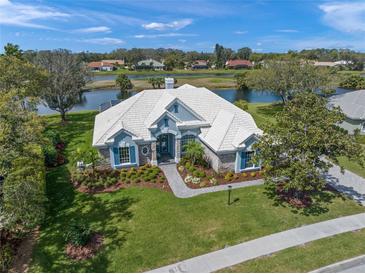 An elegant home boasts lush landscaping and serene water views from its vantage point at 8807 Wild Dunes Dr, Sarasota, FL 34241