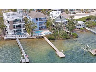 Waterfront homes boast private docks, pools, and lush landscaping along a tranquil bay at 2407 Avenue A, Bradenton Beach, FL 34217