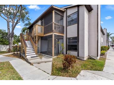 Two-story condo building with screened patios, light-colored facade, and wood stairway at 3758 59Th W Ave # 4099, Bradenton, FL 34210