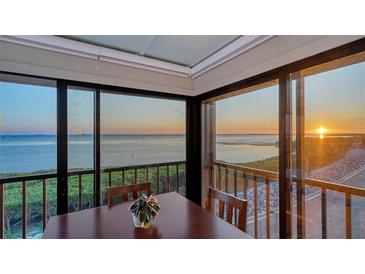 Dining room featuring panoramic water views, wood railing, and serene atmosphere at 4535 Bay Club Dr, Bradenton, FL 34210