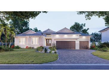 Beautiful single-story home featuring a three-car garage, manicured lawn, and a paver driveway at 5103 Windward Ave, Sarasota, FL 34242