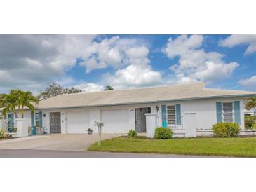 Charming single-story villa with tile roof, white exterior and vibrant blue shutters and accents at 7402 8Th W Ave, Bradenton, FL 34209