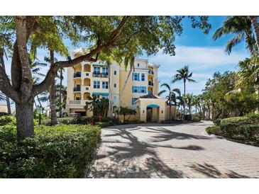 Stunning condo exterior featuring a lush landscape and brick-paved entrance, promising luxury living with a scenic backdrop at 2161 Gulf Of Mexico Dr # 3, Longboat Key, FL 34228