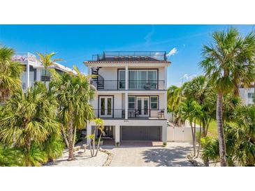 Stunning three-story home featuring a rooftop deck, balconies, and lush landscaping at 4101 4Th Ave, Holmes Beach, FL 34217