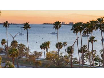 Stunning waterfront view with palm trees and boats on the horizon during a colorful sunrise at 435 S Gulfstream Ave # 601, Sarasota, FL 34236