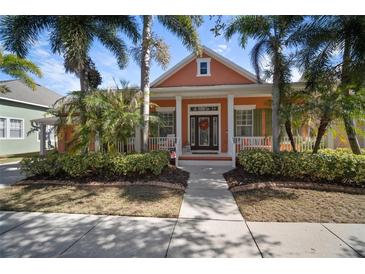 Charming, colorful one-story home with front porch, well maintained landscaping, and mature palm trees at 5715 Sea Trout Pl, Apollo Beach, FL 33572