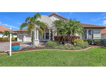 Charming home with well-manicured front lawn and beautiful tropical landscaping at 6621 The Masters Ave, Lakewood Ranch, FL 34202