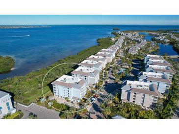 Beautiful aerial view of waterfront condos with stunning bay views and lush landscaping at 396 Aruba Cir # 302, Bradenton, FL 34209