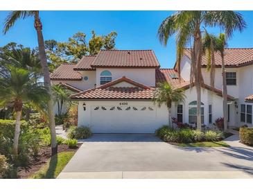 Charming home with red tile roof, a two-car garage and mature tropical landscaping around the house at 4416 Calle Serena, Sarasota, FL 34238