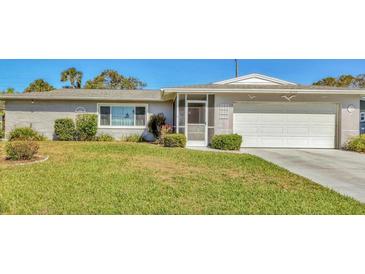 Charming single-story home with a well-maintained lawn, screened front door and a white garage at 6732 Keystone Dr, Sarasota, FL 34231