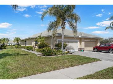Well-maintained home exterior with lush landscaping, paver driveway, and attached two-car garage at 9847 Hawk Nest Ln, North Port, FL 34287
