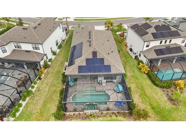 Aerial view of home with solar panels and screened pool, spa, and outdoor seating at 10179 Milky Way Cir, Sarasota, FL 34241