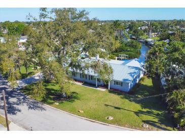 Beautiful single-story home with a metal roof, well-manicured lawn, and mature trees at 115 65Th Street Nw Ct, Bradenton, FL 34209