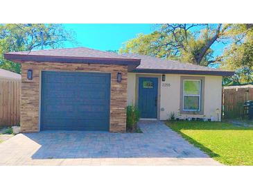 Charming single-story home with a blue front door, stone accents, and a well-manicured lawn at 2255 Chester Ave, Sarasota, FL 34234