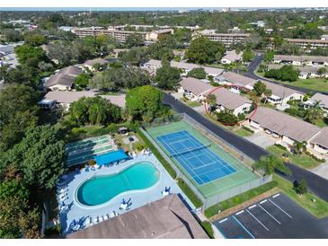 Community aerial view showcasing the pool, tennis courts, and low-maintenance villas in a lush setting at 390 301 W Blvd # 13A, Bradenton, FL 34205