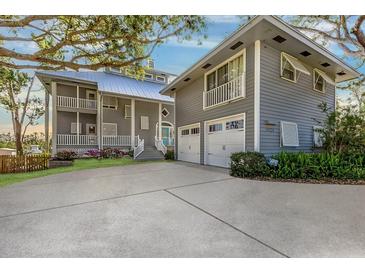 Beautiful two-story home featuring a two-car garage, light gray siding, lush lawn and lovely landscaping at 3924 Riverview Blvd, Bradenton, FL 34209