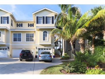 Charming yellow two-story townhome with garage, driveway, landscaping and a sunny curb appeal at 449 Canal Rd # 449, Sarasota, FL 34242