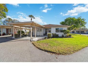 Charming single-story home featuring a covered carport, manicured lawn, and welcoming front entrance at 5020 Live Oak Cir, Bradenton, FL 34207