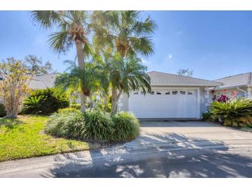 Charming single-story home with lush tropical landscaping and a two-car garage at 5608 Country Club Way # 5608, Sarasota, FL 34243