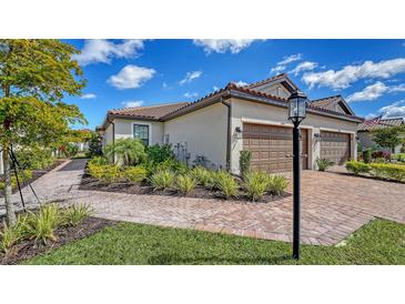 Charming exterior with a brick driveway, manicured landscaping, and a welcoming entrance at 6070 Mesa Gln, Bradenton, FL 34203