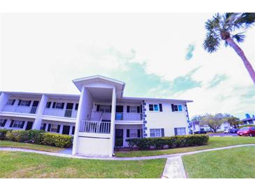 Two story condo building showing balconies, lawn, shrubbery, sidewalk and a palm tree at 105 47Th Avenue W Dr # 377, Bradenton, FL 34207