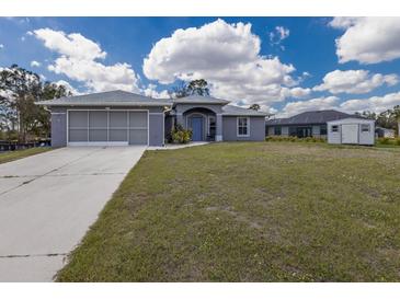 Charming single-story home with a well-maintained lawn, attached garage, and inviting entrance at 1269 Rasp Ct, North Port, FL 34288