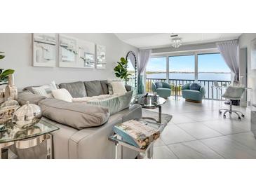 Modern living room features views of the ocean, stylish furniture, and lots of natural light at 1602 Stickney Point Rd # 404, Sarasota, FL 34231