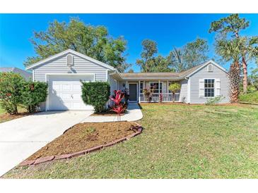 Charming single-story home featuring a well-maintained lawn and a quaint front porch entrance at 1761 Shevlin St, North Port, FL 34286