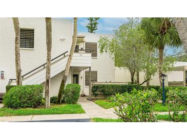 Two-story condo featuring lush landscaping, private entrances, and a textured facade at 333 Springdale Dr # 333, Bradenton, FL 34210