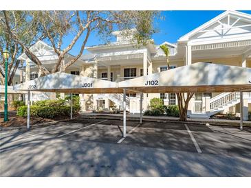 Inviting condo complex with covered parking, lush landscaping, and charming architecture at 3608 54Th W Dr # 102, Bradenton, FL 34210